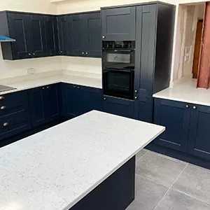 A kitchen with blue cabinets and a white counter top.