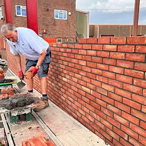 a man is working on a brick wall