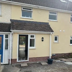 a yellow house with a blue door and windows